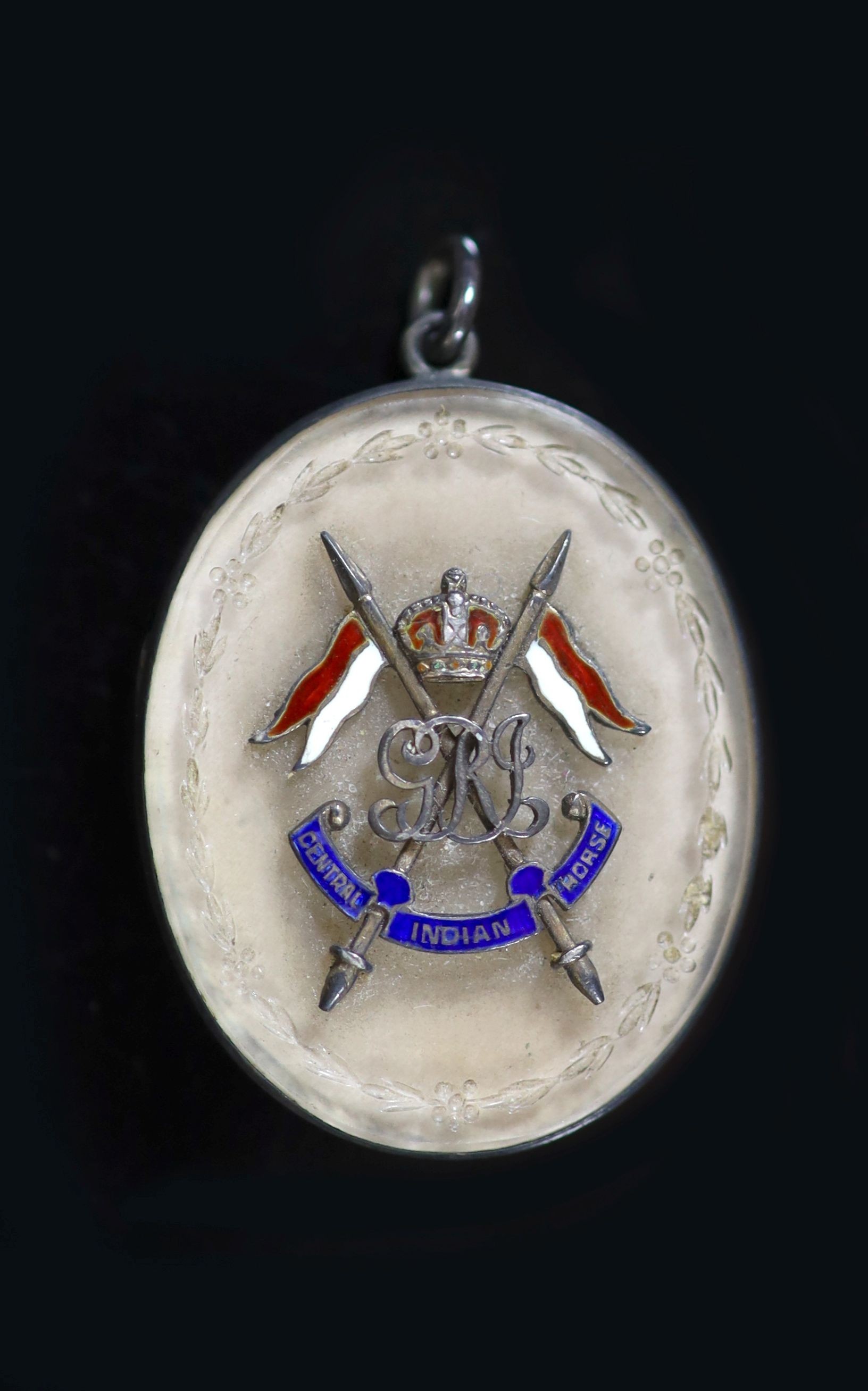 An early 20th century silver, rock crystal? and enamel set 'Central Indian Horse' cavalry regiment oval pendant locket